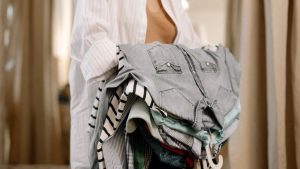 Donna con diversi vestiti in mano